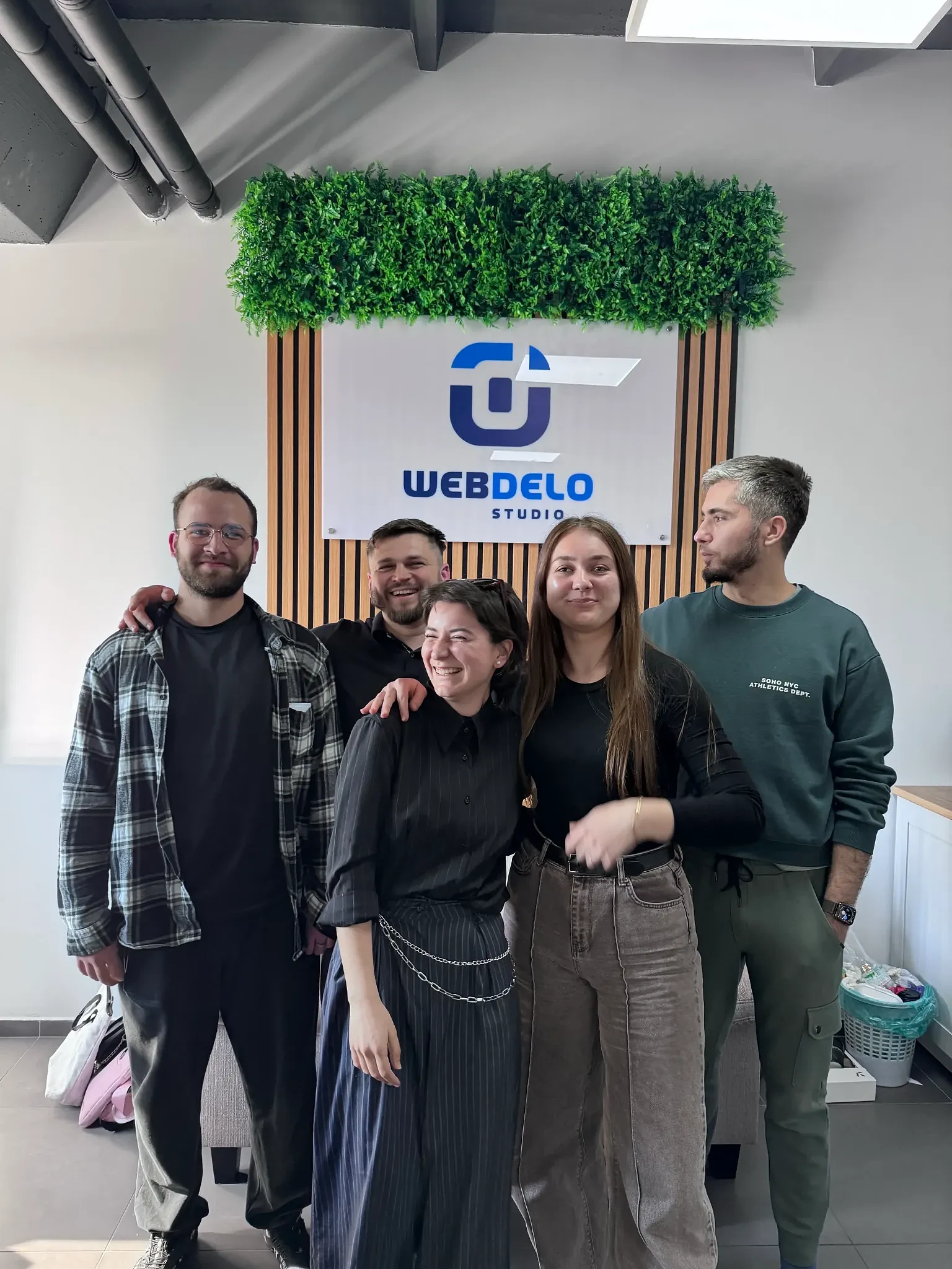 SEO-, Design- und Entwicklungsteam von Webdelo vor dem Markenbanner.